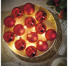 Globuri decorative roșii de Crăciun cu șir de lumini pe o tavă