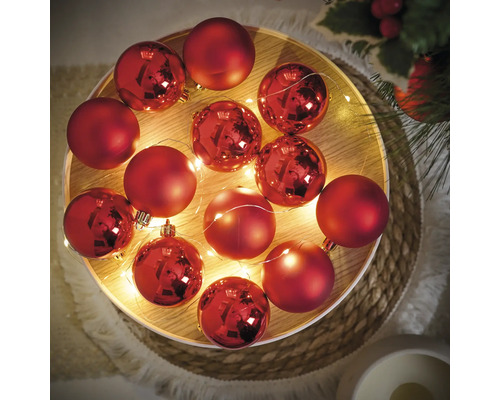 Globuri decorative roșii de Crăciun cu șir de lumini pe o tavă