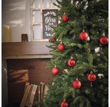 Pom de Crăciun împodobit cu globuri roșii în camera de zi.
