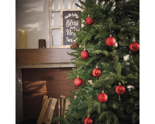 Pom de Crăciun împodobit cu globuri roșii în camera de zi.