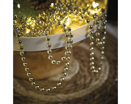 Șirag de mărgele aurii pentru decor într-un bol