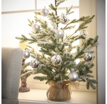 Brad mic de Crăciun cu globuri decorative într-un sac de iută