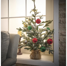 Brad artificial de Crăciun decorat pe pervazul ferestrei