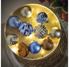 Globuri de Crăciun multicolore pe o tavă din lemn iluminată