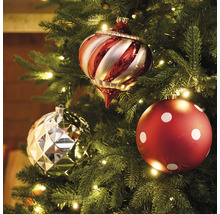 Trei globuri de pom de Crăciun într-un brad de Crăciun cu lumini.