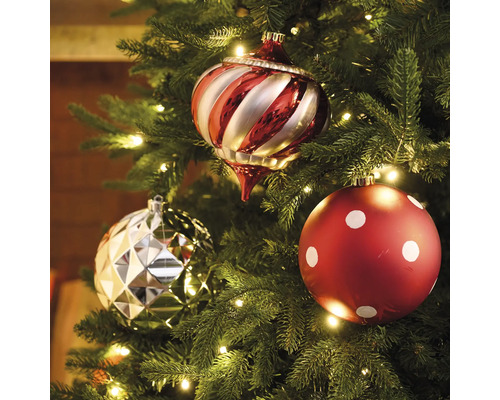 Trei globuri de pom de Crăciun într-un brad de Crăciun cu lumini.