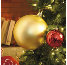 Prim-plan cu un brad de Crăciun cu globuri aurii și roșii și luminițe