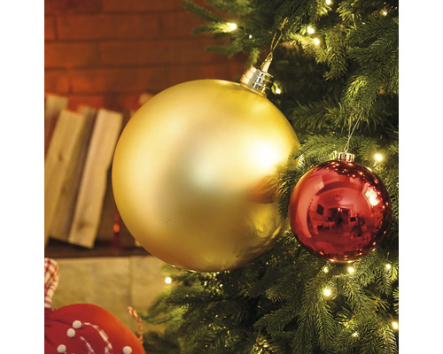 Prim-plan cu un brad de Crăciun cu globuri aurii și roșii și luminițe