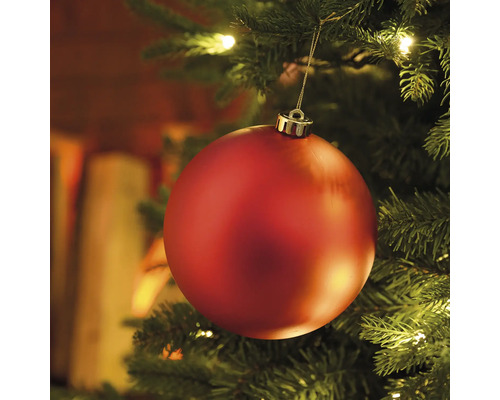 Prim-plan cu un glob roșu de Crăciun într-un brad cu lumini