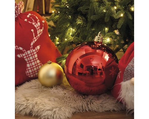 Scenă decorativă de Crăciun cu globuri de pom, sac de cadouri și instalație luminoasă sub un brad de Crăciun