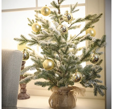 Brad decorativ de Crăciun, acoperit cu zăpadă, cu globuri aurii într-un sac de iută