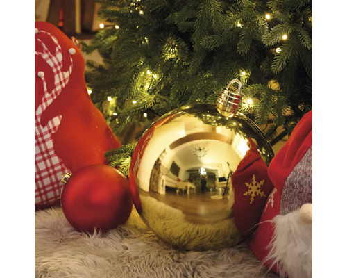 Scenă cu globuri de Crăciun și decorațiuni pe un covor sub un brad de Crăciun