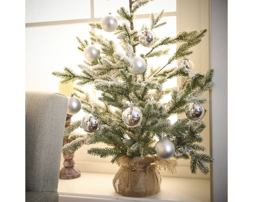 Pom de Crăciun artificial, decorativ, mic, cu globuri argintii într-un sac de iută