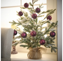 Brad artificial de Crăciun cu globuri decorative într-un sac de iută