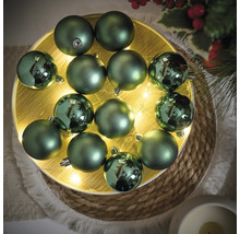 Globuri decorative verzi de Crăciun pe o farfurie iluminată