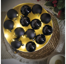 Aranjament de globuri negre de Crăciun într-un bol iluminat