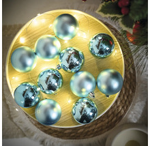 Globuri decorative albastre de pom de Crăciun pe o tavă cu șir de lumini