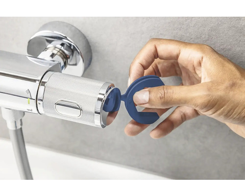 Mână care atașează un instrument albastru la un robinet