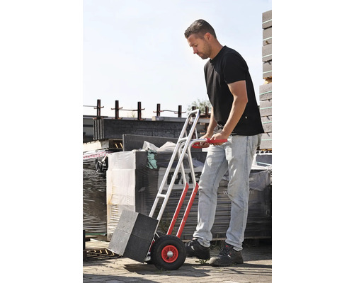 Bărbat transportă pavaj cu un cărucior.