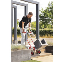 Un bărbat transportă jardiniere folosind un cărucior de scară