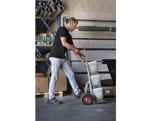 Un bărbat transportă mortar pentru rosturi pavaj Aqua Easy pe un cărucior