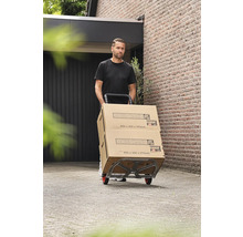 Bărbat transportând cutii Hornbach pe un cărucior