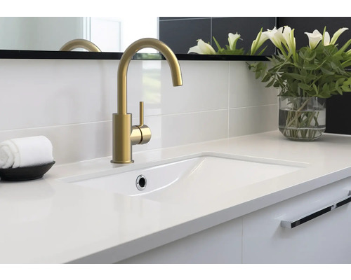 Mobilier de baie cu robinet auriu, lavoar alb și vază de flori decorativă