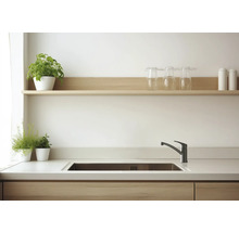 Bucătărie luminoasă cu chiuvetă, robinet, blat de lucru și rafturi cu decorațiuni