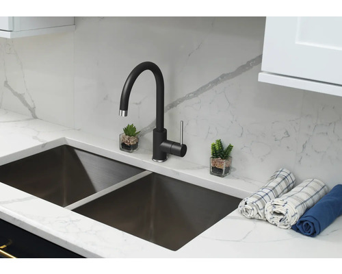 Chiuvetă de bucătărie cu robinet negru, blat și două decorațiuni mici