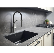 Scenă de bucătărie cu chiuvetă, robinet, plită și blat de lucru într-un design modern.