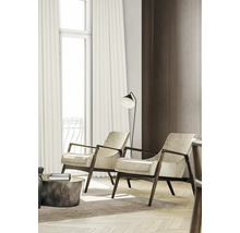 Living cu două fotolii, lampă de podea și perdele la fereastră.