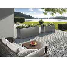 Scenă cu două jardiniere metalice dreptunghiulare pe o terasă cu vedere la lac