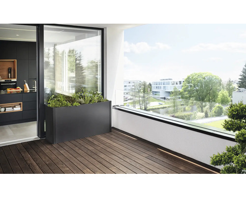 Scenă a unei terase cu o jardinieră metalică plantată pe o podea de lemn