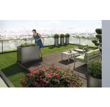 Terasa cu mobilier de grădină, jardiniere și o femeie care îngrijește plantele