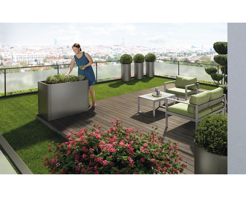 Terasa cu mobilier de grădină, jardiniere și o femeie care îngrijește plantele