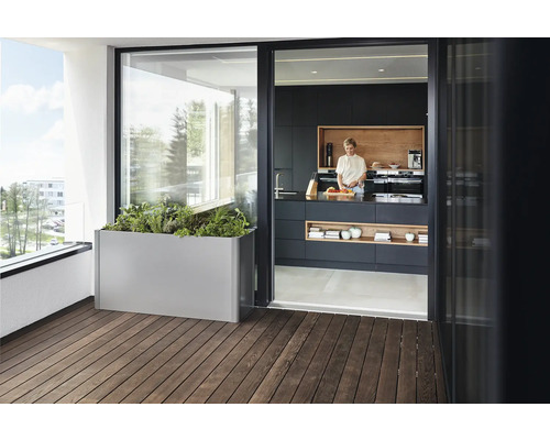 Scenă de balcon cu jardinière metalică și femeie într-o bucătărie modernă