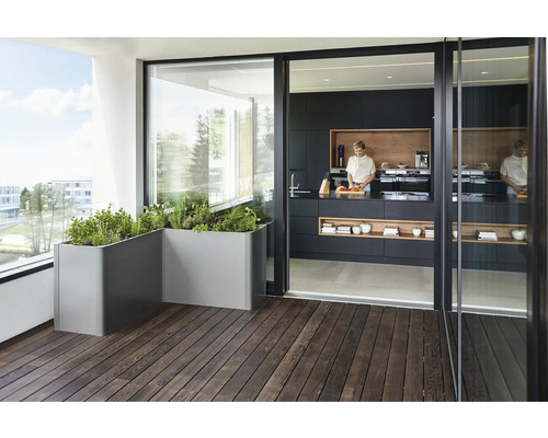 Balcon cu jardiniere metalice și bucătărie adiacentă cu mobilier închis la culoare