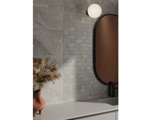 Baie cu plăci de faianță gri cu aspect de piatră, oglindă și lampă