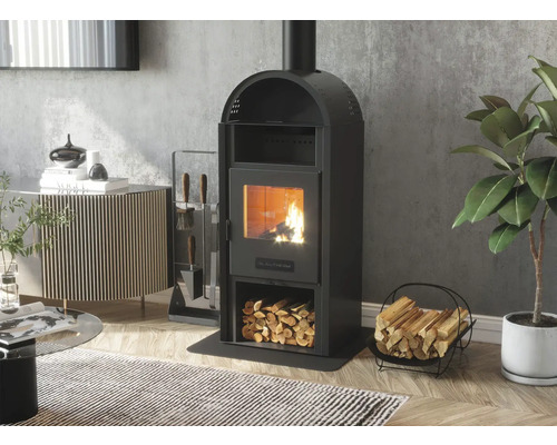 Șemineu independent pe lemne cu compartiment pentru lemne și ustensile pentru șemineu lângă coșul pentru lemne în camera de zi.