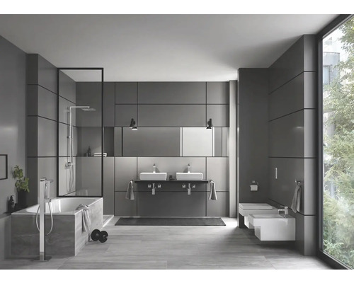 Baie modernă cu cadă, duș, chiuvetă dublă și toaletă.