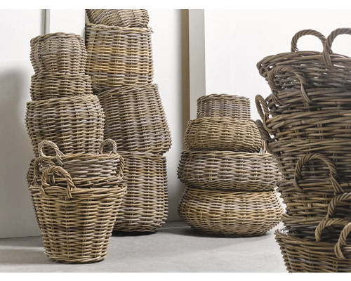 Mai multe coșuri de răchită stivuite de diferite dimensiuni cu mânere.