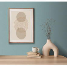 Tablou decorativ înrămat cu design geometric abstract pe o masă cu vază, ceașcă și cărți
