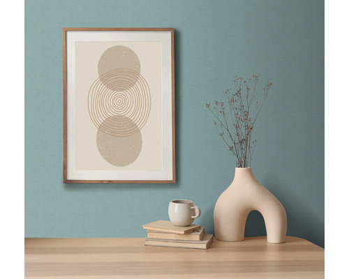 Tablou decorativ înrămat cu design geometric abstract pe o masă cu vază, ceașcă și cărți