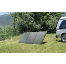 Panou solar portabil pe un gazon lângă o rulotă