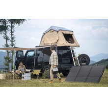 Scenă de camping cu mașină, cort pe acoperiș, panouri solare și persoane care desfășoară activități în aer liber