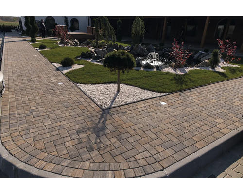 Drum pavat care duce printr-o grădină cu fântână.