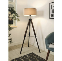 Lampă de podea cu trepied din lemn și abajur într-o cameră luminoasă