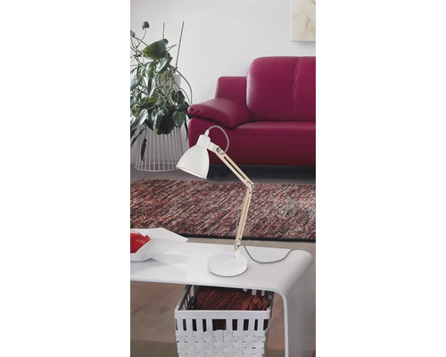 Lampă de birou albă cu detalii din lemn pe o masă din camera de zi