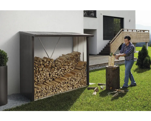 Depozit de lemne cu lemne de foc și bărbat care taie lemne în grădină.