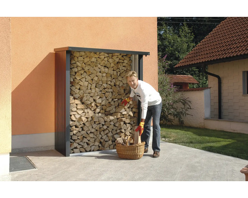 Persoană umplând coș de lemn la un suport de lemn